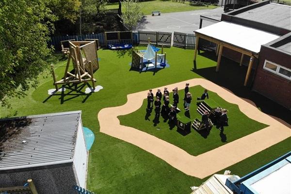 All Saints Primary’s updated playground featuring artificial turf, wooden climbing structures, and interactive play zones, designed to promote active and creative outdoor learning.