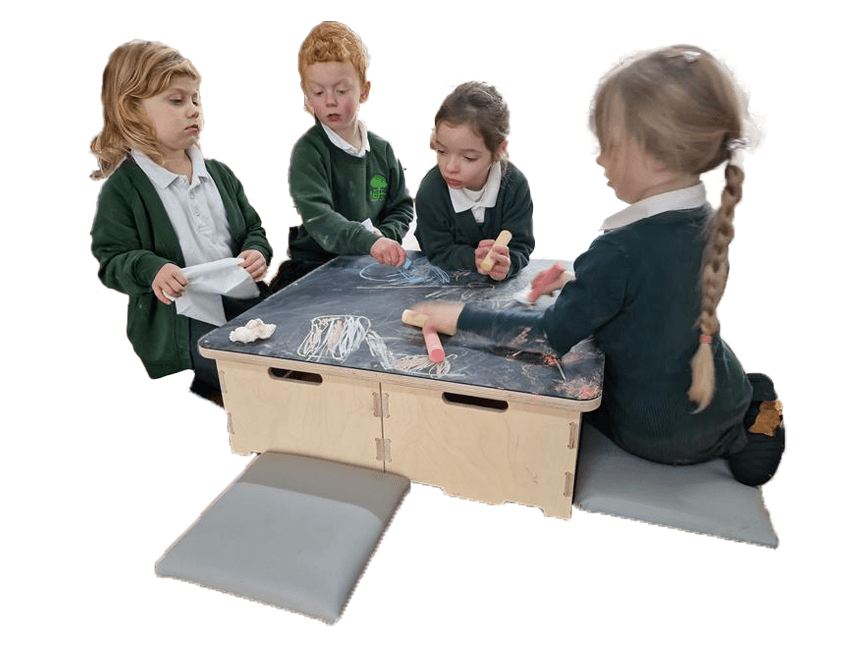 4 school children sat around art easel on stack and sit stools drawing with chaulk