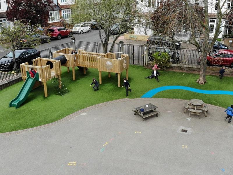 brand new playground with artificial grass and a large play tower
