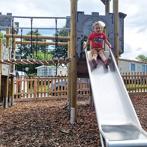 child sliding down on play tower in caravan holiday park