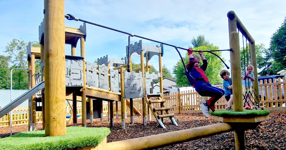 child climbing on trim trail in pub garden playground