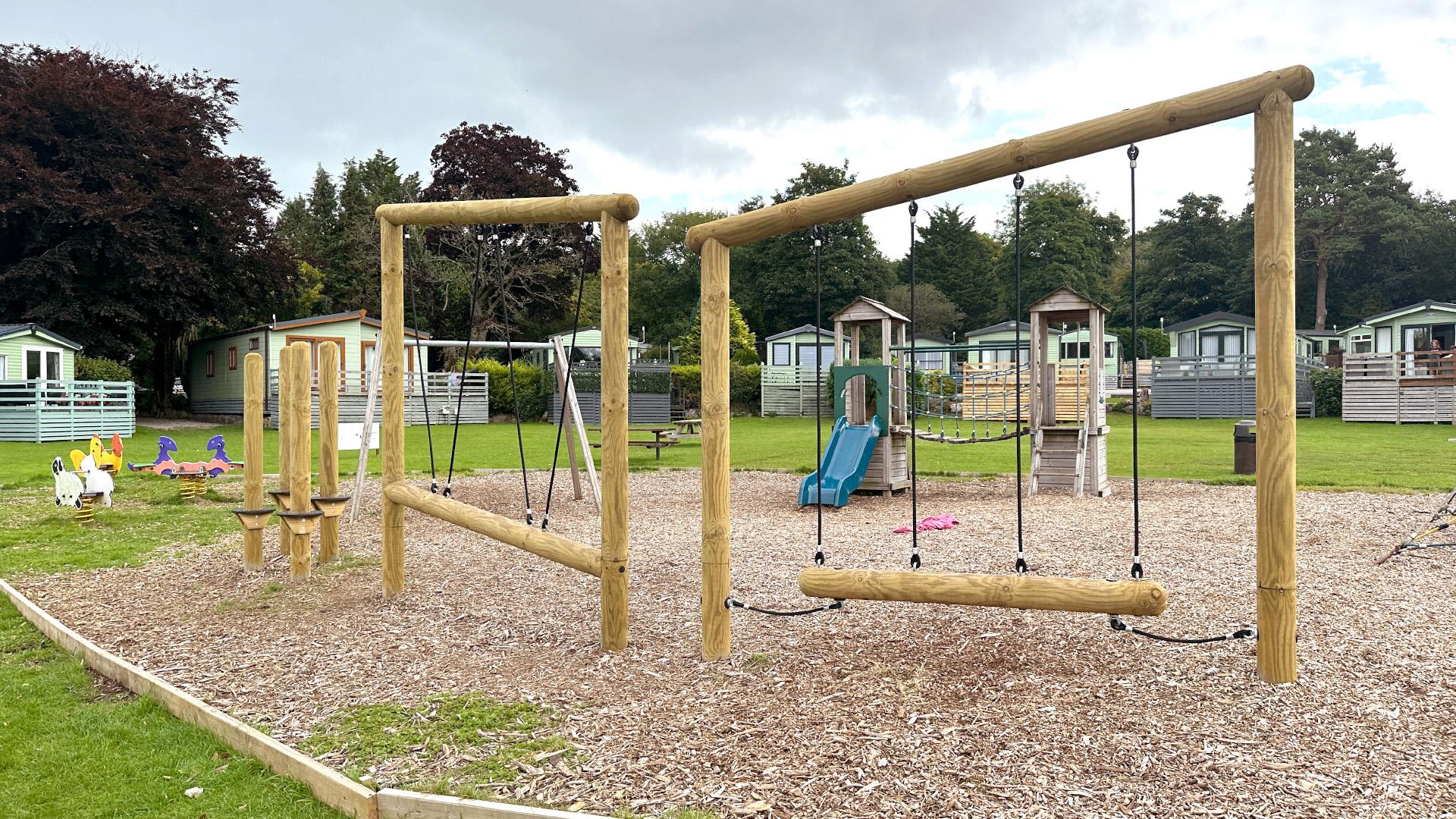multi-use-games-area with artificial grass and fencing alongside a clmbing frame, play tower, outdoor classroom and tyre trim trail