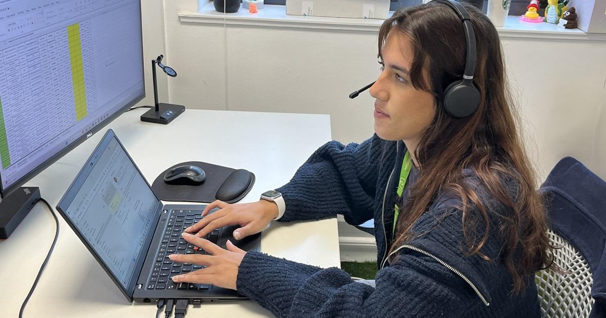 A woman who works in Inspectitions and Maintenance team is talking on the phone as she works on her computer