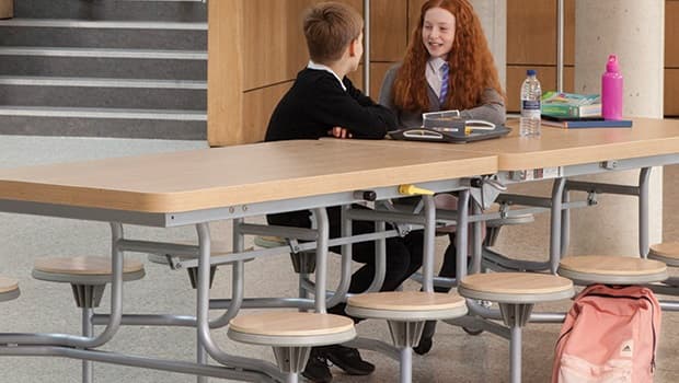 two primary school students sitting at a SpaceRight school dining table having a conversation