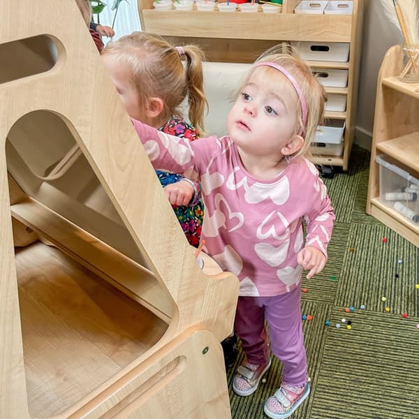 A nursery child playing with Millhouse Easel