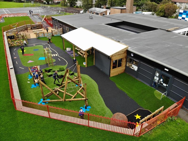 primary school with new playground area provided by Pentagon Play including artificial grass, climbing equipment and an outdoor shelter