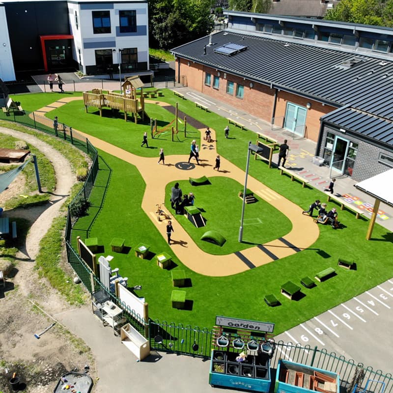 a drone image of a large school playground with new surfacing, astroturn, a wooden play tower, Get Set, Go! Blocks and many other play products