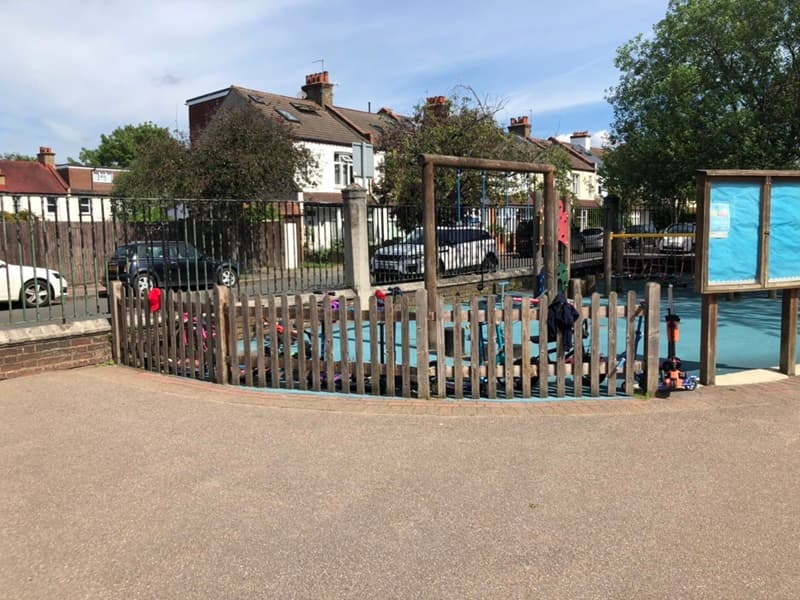 run-down playground with old wooden fencing and swing