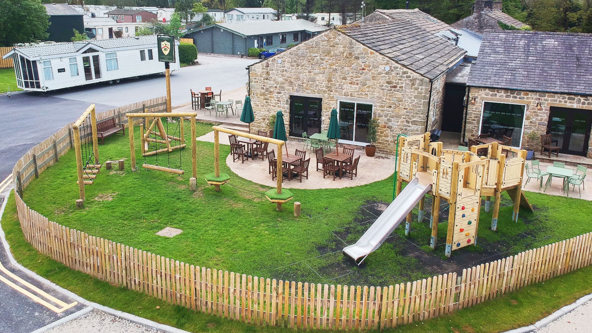 multi-use-games-area with artificial grass and fencing alongside a clmbing frame, play tower, outdoor classroom and tyre trim trail
