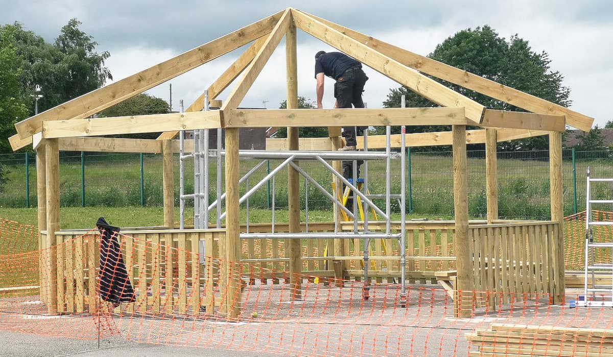 builders installing outdoor gazeobo for a learning space in a primary school field