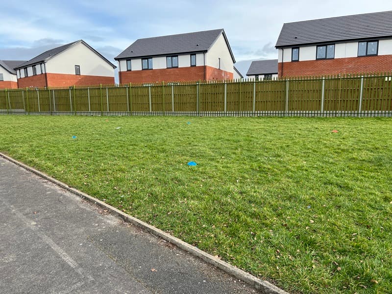 empty grass play area with no playground equipment